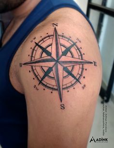 a man with a compass tattoo on his arm