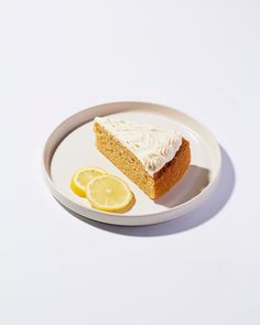 a piece of cake on a plate with lemon slices