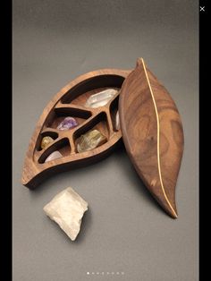 a wooden box filled with stones on top of a gray table next to a rock