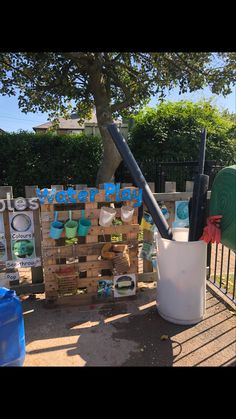 there is a bucket and shovel on the side of a fenced in area with other items