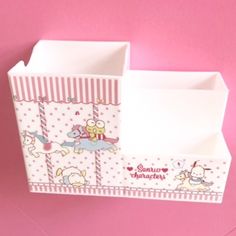 two small boxes are sitting side by side on a pink surface, one has an animal and the other is unicorns