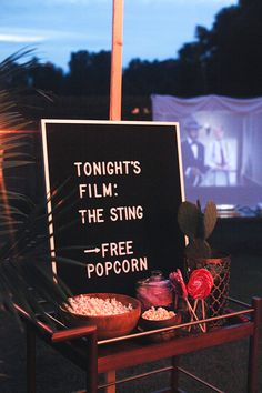 a sign that says tonight's film the sting is free popcorn and two bowls of popcorn