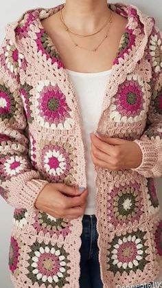 a woman is wearing a pink crocheted sweater with flowers on the front and sides