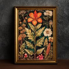 a painting on a wall with flowers and leaves in the frame, against a dark background