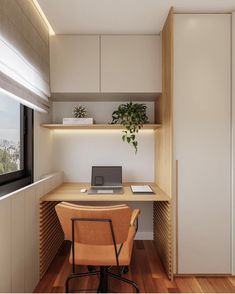 a desk with a laptop computer on top of it next to a chair and window