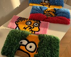 three towels with cartoon characters on them sitting on top of a white table next to each other