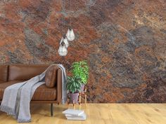 a brown leather couch sitting in front of a wall covered in red and gray rocks