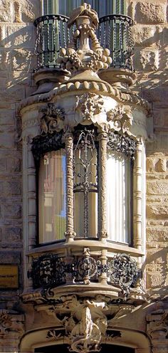 an old building with ornate iron work on the front and sides, along with a clock