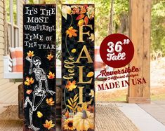 two tall wooden signs with skeletons and autumn leaves on them, one is painted black and the other is white