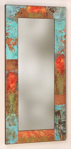 a mirror that is sitting on top of a wall next to a vase with flowers