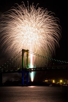 fireworks are lit up in the sky above a bridge