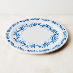 a blue and white plate sitting on top of a marble counter next to a wall