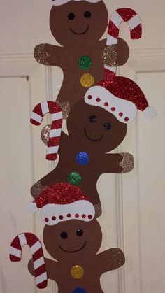 christmas decorations made out of gingerbreads and candy canes hanging from a door