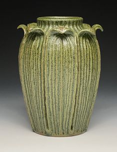 a large green vase sitting on top of a table