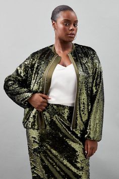 a woman in a green sequin skirt and jacket standing with her hands on her hips