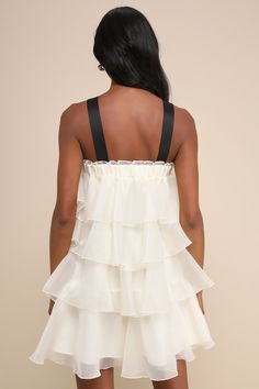 You'll flutter your way into everyone's hearts in the Lulus Deluxe Vision Ivory and Black Tiered Bow Shift Mini Dress! Airy woven organza shapes this stunning little dress that has contrasting black satin straps that support a shift-style silhouette with a straight, elasticized neckline and an iconic bow accent at the front. Luxe tiers run down the silhouette, finishing at a mini hem. Fit: This garment fits true to size. Length: Mid-thigh. Bust: Great for any cup size. Waist: Not Fitted - comfortable room throughout midsection. Hip: Not Fitted - room for hips. Undergarments: May be worn with a strapless bra, adhesive bra, petals, or no bra. Fabric: Fabric has no stretch. Lined. Shell: 100% Polyester. Contrast: 100% Polyester. Lining: 100% Polyester. Hand Wash Cold. Do Not Bleach. Line Dry. Long Sleeve White Dresses, Long Sleeve White Dress Short, Dresses For Women Short, Graduation 2025, Black And White Dresses, Mini Dress With Bow, Shift Mini Dress, Dresses Lulus, Tier Dress