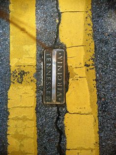 a street sign that is sitting on the side of a yellow and black striped road