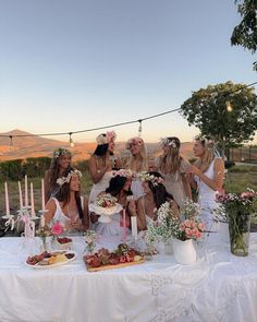 a group of women sitting at a table with cake and candles in front of them