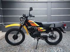 a yellow and black motorcycle parked in front of a building