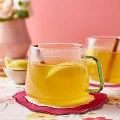 two glasses filled with yellow liquid sitting on top of a table