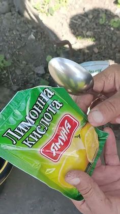 a person holding a bag of lemons next to a spoon