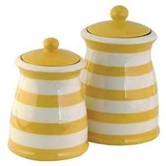 two yellow and white striped canisters sitting next to each other on a white background