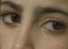 a close up of a woman's face with brown eyes