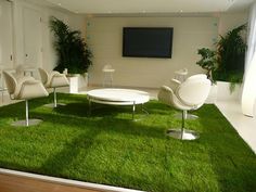 a living room filled with white furniture and green grass