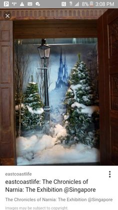 a snow scene in a wooden frame with a street light and trees covered in snow