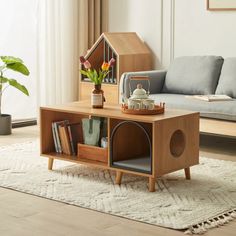 a living room with a couch, coffee table and bookshelf on the floor