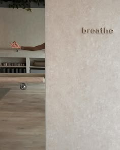 a person standing in front of a wall with the word breathe written on it's side