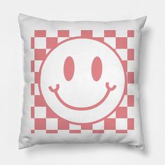 a square pillow with a smiley face on it's side and checkered background