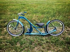 a blue bicycle parked on top of a lush green field