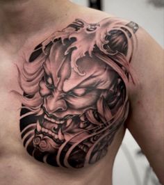 a man with a tattoo on his chest is wearing a black and grey dragon head