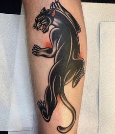 a black panther tattoo on the left leg and right leg, with red eyes in it's center