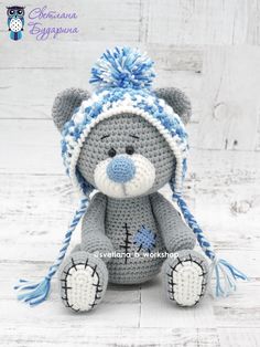 a crocheted teddy bear wearing a blue and white hat