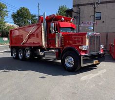 a red dump truck parked in front of a building