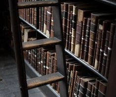 an old bookshelf filled with lots of books on it's sides and ladders