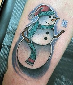 a snowman with a hat and scarf tattoo on the leg, it looks like he is