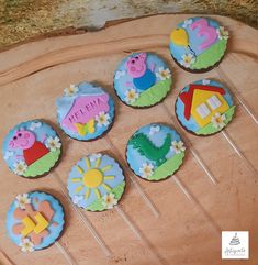 decorated cupcakes sitting on top of a wooden board with stickers in the shape of animals