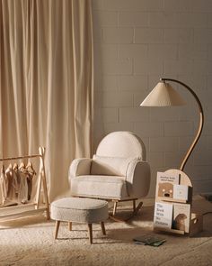 a chair and footstool in front of a brick wall with curtains behind it