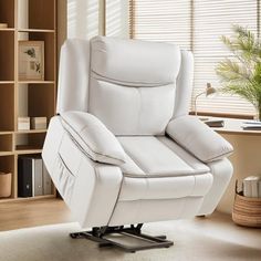 a white reclining chair sitting on top of a wooden floor next to a window