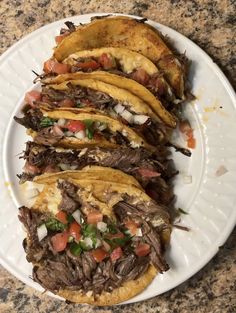 a white plate topped with tacos and meat