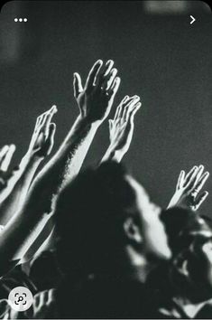 black and white photograph of people raising their hands