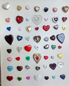 there are many different colored hearts on the wall