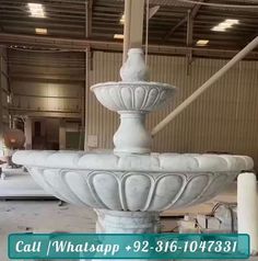 a large white fountain sitting inside of a building