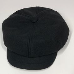 a black hat is sitting on a white surface