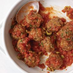 a white bowl filled with meatballs and sauce