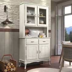 a white china cabinet sitting next to a window in a room with wood flooring