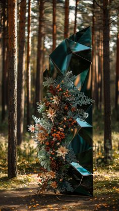 a sculpture in the middle of a forest with lots of leaves and flowers on it